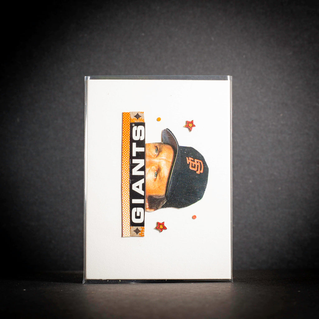 Card with a baseball player wearing a Giants cap on a dark background