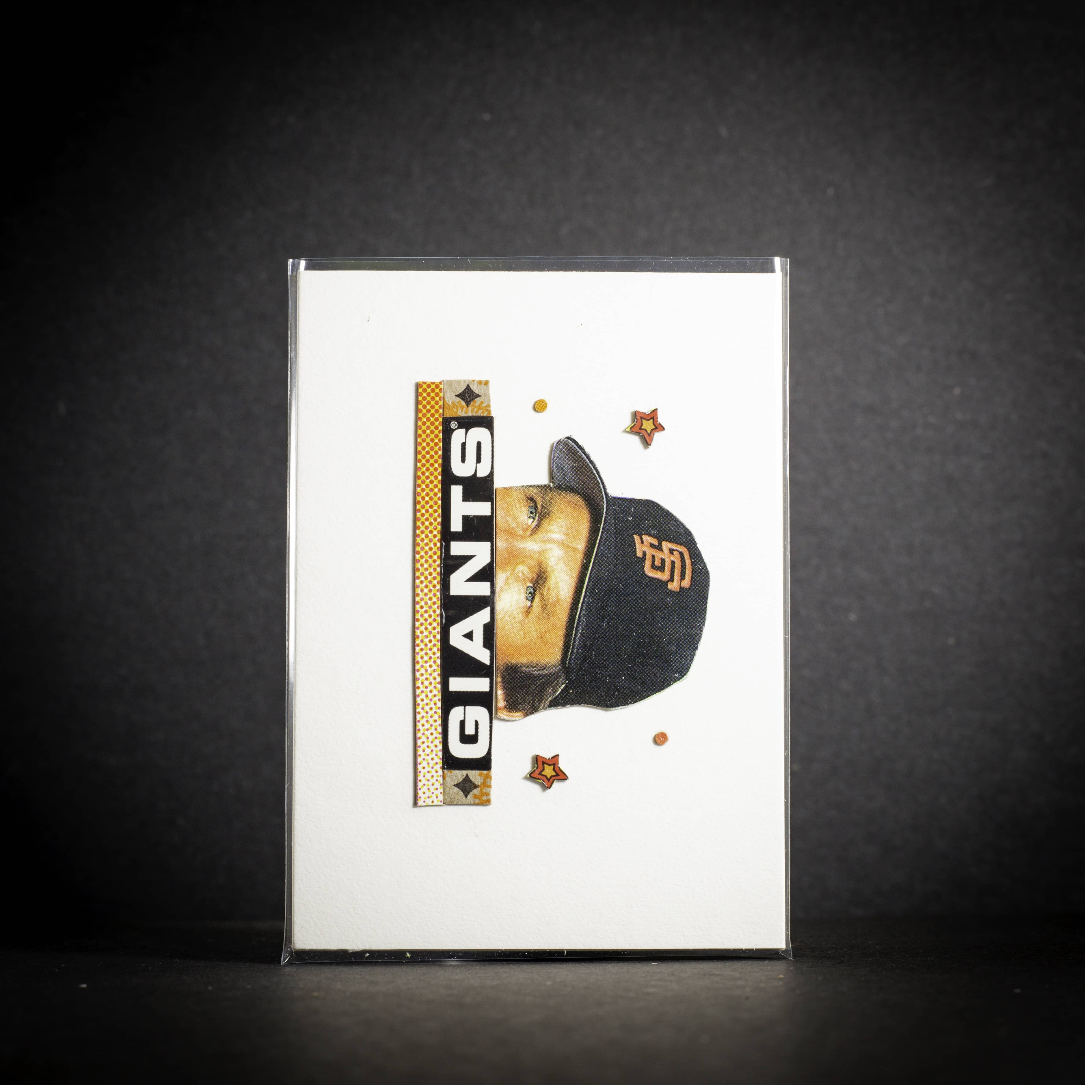 Card with a baseball player wearing a Giants cap on a dark background