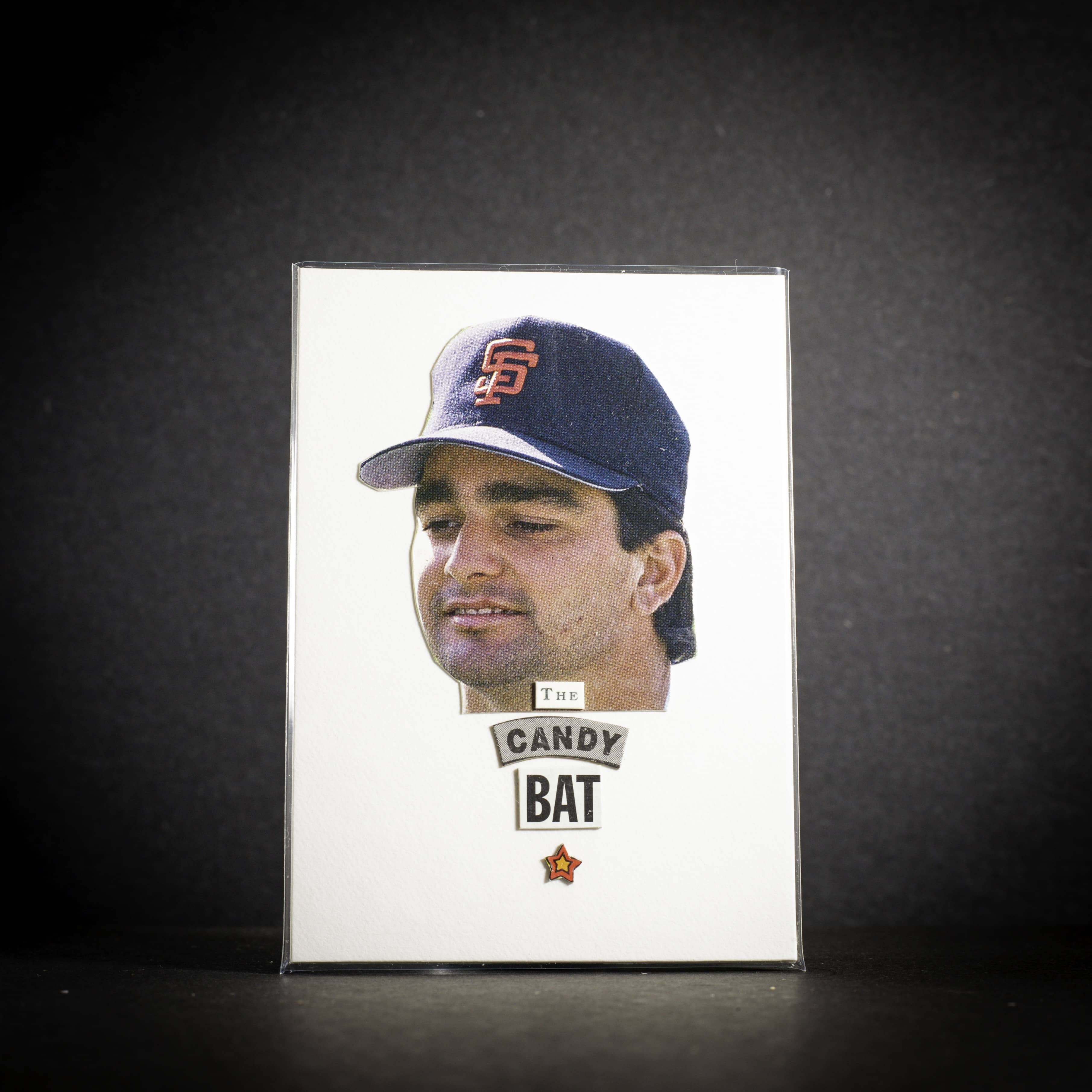 Trading card of a baseball player wearing a cap with 'Candy Bat' branding on a dark background