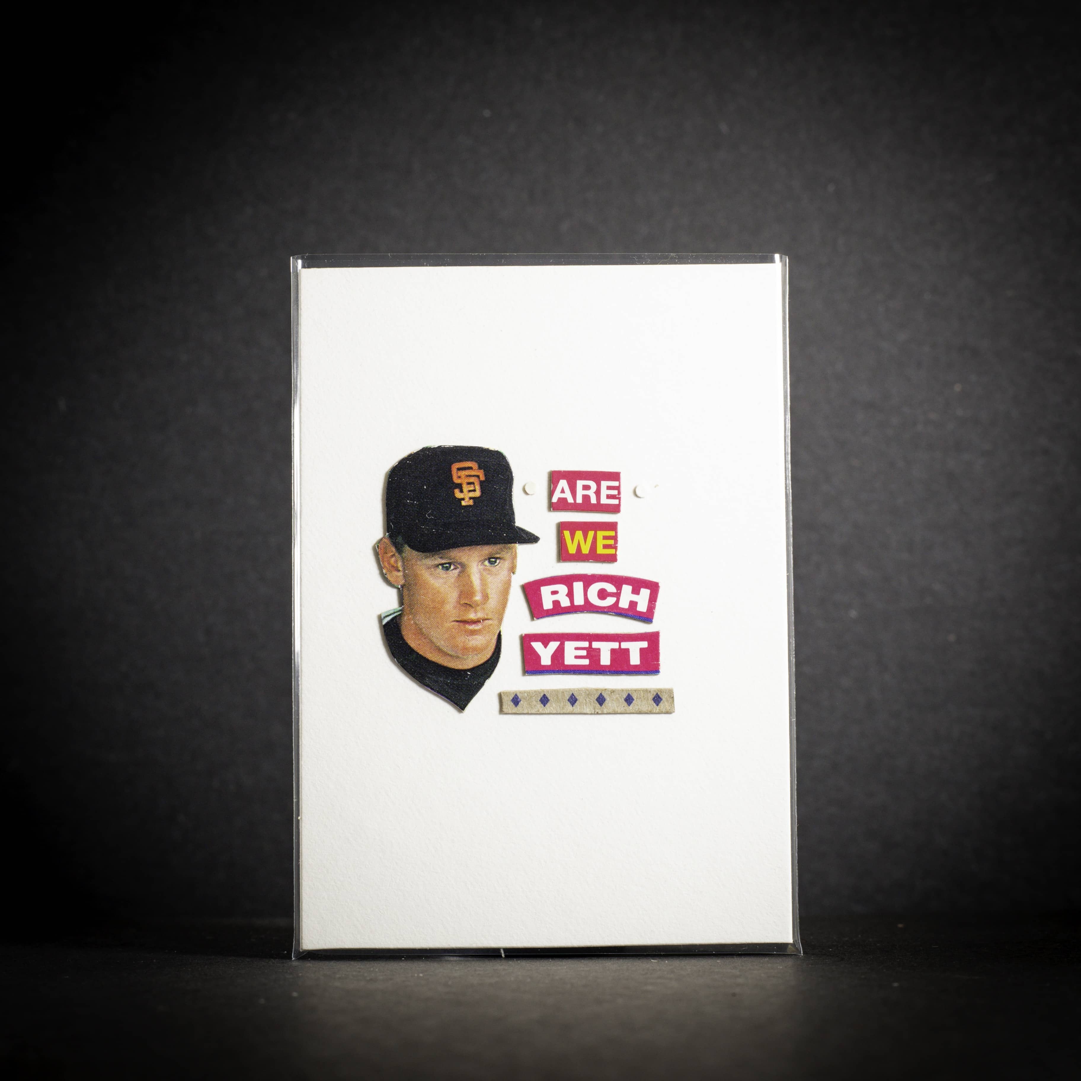 Baseball card of a player with text 'Are We Rich Yett?' on a dark background