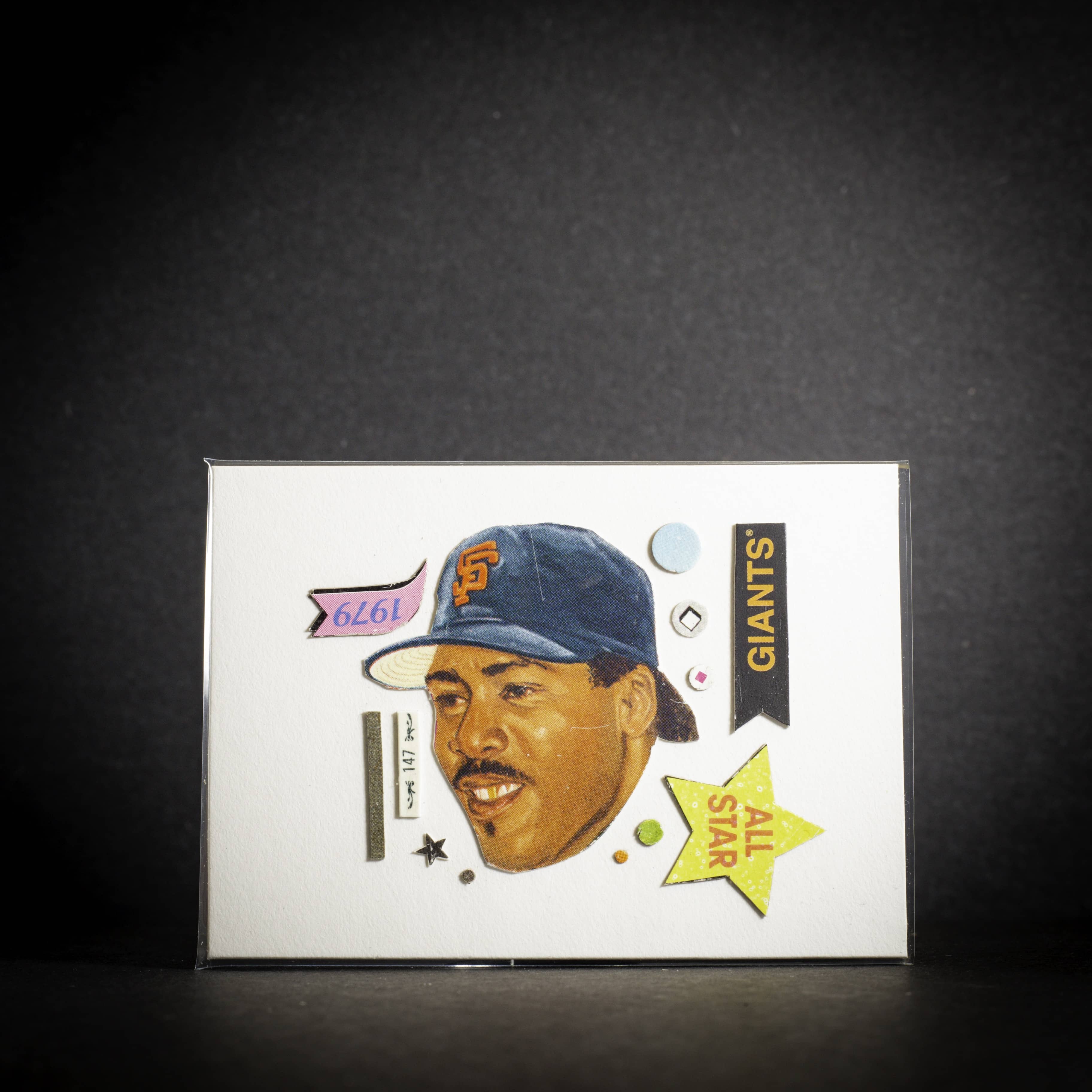 Baseball trading card of a player wearing a Giants cap on a dark background
