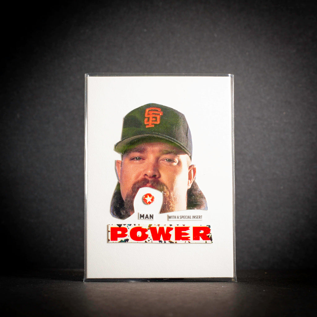 Trading card of a person wearing a cap with a logo, on a dark background